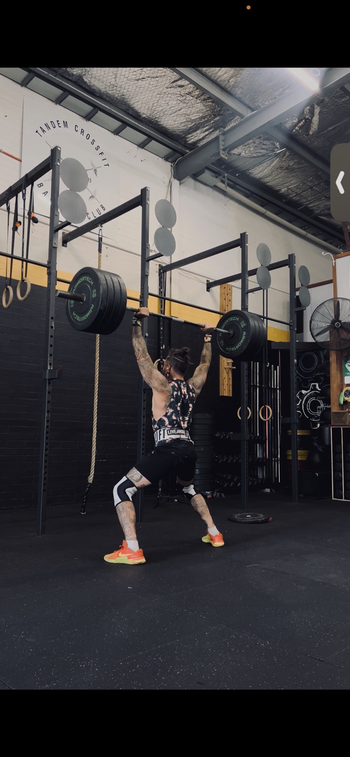Jotik Serje performing an overhead barbell lift during strength and skills training